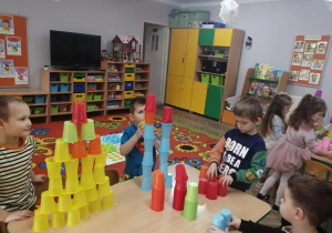 Chłopcy ustawiają swoje wieże według własnego pomysłu w kolorze żółtym, czerwonym, niebieskim.