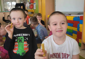 Bartuś i Franek z grupy Słoneczek z dumą prezentują świeczki jakie samodzielnie wykonali z wosku pszczelego