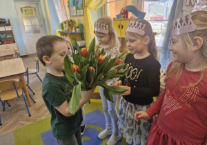 Bartuś wręcza dziewczynkom tulipany.