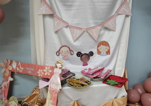 Zdjęcie przedstawiające dekorację, foto ramkę i upominki dla dziewczynek.