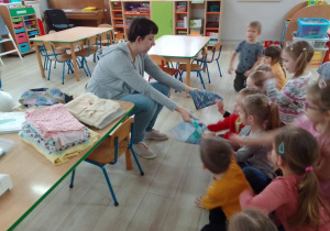 Pani Katarzyna prezentuje dzieciom różne rodzaje materiałów.