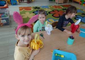 Ula, Maja i Natalia prezentują skonstruowane przez siebie koszyczki z kolorowego papieru.