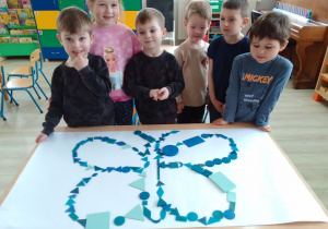 Druga grupa dzieci prezentuje ułożonego z niebieskich kształtów motyla.