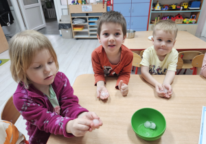 Nadia, Wojtek Z i Ignaś siedzą przy stoliku trzymając w dłoniach kostki lodu.