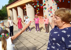 Dzieci zgromadzone na tarasie podczas zabawy z balonem z konfetti.