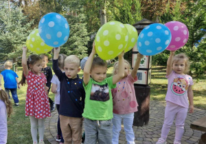 Dzieci podczas zabawy z balonami na świeżym powietrzu.