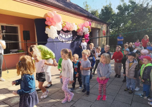 Dzieci i przechodzą pod liną. W tle dekoracja z balonów.