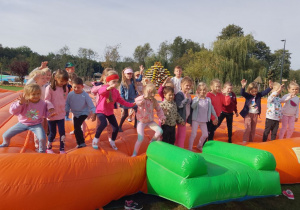 Dzieci skaczą na dyniowej trampolinie.