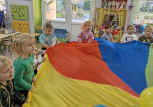 Wojtuś, Nadia, Maja, Maja, Wojtuś, Klara i Olek w trakcie zabaw z chustą animacyjną.