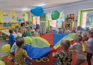 Dzieci z grupy "Motylki" podrzucają balony na chuście animacyjnej.