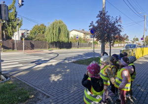 Dzieci z grupy „Motylków” przyglądają się działaniu sygnalizatora świetlnego.