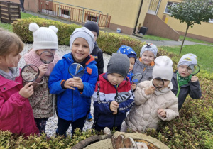 Przedszkolaki stoją przy mrowisku.