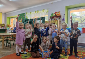 Przedszkolaki z grupy Motylków prezentują zdobyte w grze terenowej nagrody.