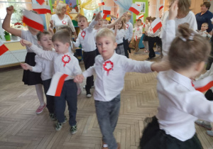 Przedszkolaki razem z paniami jadą w pociągach przy piosence "Jestem Polakiem". Wszyscy trzymają biało-czerwone flagi.