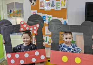 Klara i Marcel pozują do zdjęcia w foto - ramce Myszki Miki i Myszki Minnie.