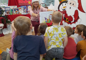 Pani Edyta pokazuje dzieciom obrazek w książce pt. "Święty Mikołaj wchodzi kominem".