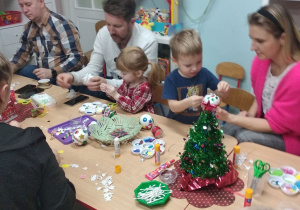 Józio z mamą, Jagoda z tatą i tata Olka w trakcie pracy przy bombce.