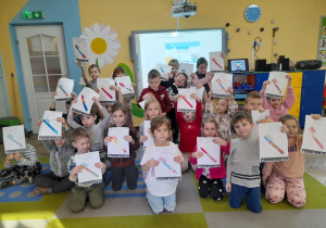 Dzieci prezentują wykonaną przez siebie kartę pracy ze szczoteczką do zębów.