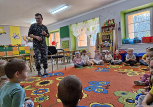 Przedstawiciel firmy "Ranczowisko" stoi przed grupą dzieci i tłumaczy jak należy zachowywać się w obecności zwierząt.