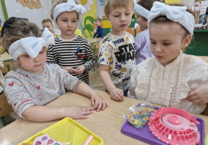 Maja, Maja, Wojtuś, i Weronika oglądają przybory do makijażu.