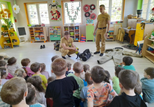 Strażacy prezentują dzieciom czujnik bezruchu.