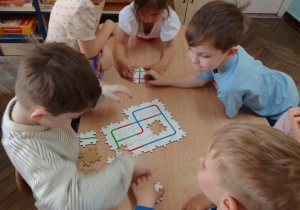 "Słoneczka" układają puzzle - drogę dla robota Ozobota.