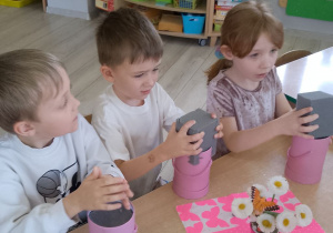 Grupka dzieci podczas wkładania gąbek do pudełek.