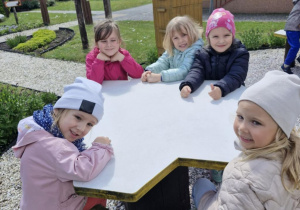 6.Dziewczynki siedzą przy stoliku w kształcie plastra miodu.