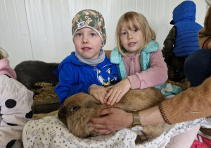 Lucjan i Nadia trzymają na kolanach królika.