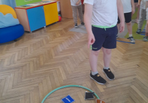 Adam stoi przed obręczą i liczy ile woreczków znajduje się w obręczy.