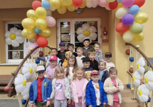 Wspólne zdjęcie dzieci z grupy "Motylków" przy balonowej dekoracji przed wejściem do przedszkola.