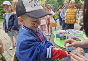 Oluś w trakcie robienia brokatowego tatuażu.