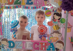 Adaś i Kuba pozują do zdjęcia w foto ramce z otrzymanymi upominkami.