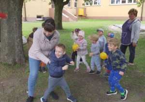 Grupka dzieci w trakcie zabawy z piłkami.