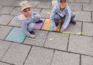 Wojtek i Tymek w trakcie malowania kredą.