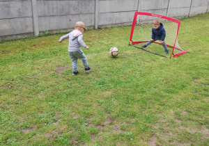 Wojtek celuje do bramki, Franio w roli bramkarza.