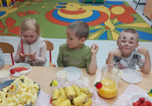 Alicja, Tymek i Filip podczas poczęstunku.