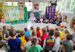 Na scenie swoja rolę prezentuje Marysia przebrana za Zajączka.Z boku siedzą dziewczynki w roli Czarownic i Julka w roli Narratora.