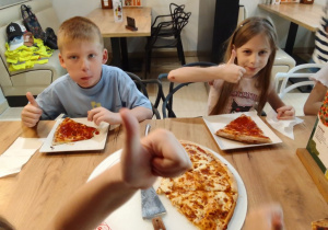 Antek i Zuzia degustują pizzę.
