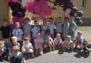 Zdjęcie grupowe „Biedronek” na tle balonów w kolorze różowo – czarnym.