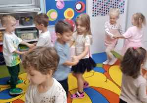 Dzieci tańczą w małych kółeczkach.