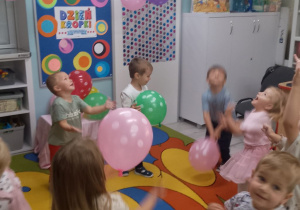 "Pszczółki" stoją w rozsypce i podrzucają balony w kropki.