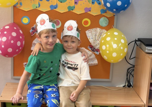 Dawid i Wojtek pozują na tle gazetki z napisem Dzień Kropki.