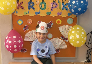 Leon pozuje na tle gazetki z napisem Dzień Kropki.
