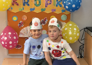 Olek i Leon pozują na tle gazetki z napisem Dzień Kropki.