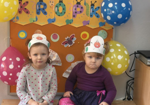 Jagoda i Kalina pozują na tle gazetki z napisem Dzień Kropki.