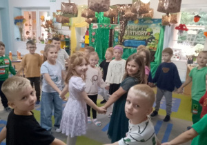 Pląsy przy muzyce: dzieci ustawione w dwóch kółkach, jedno kółko tworzą dziewczynki drugie chłopcy.