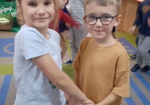 Mikołaj i Marysia tańczą trzymając się za ręce.