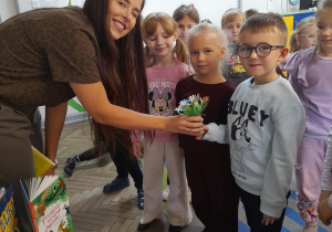 Dzieci dziękują mamie Mikołaja za piękne czytanie i wręczają własnoręcznie wykonany bukiet kwiatków.
