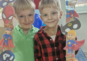 Wojtuś i Oluś pozują w foto-ramce przygotowanej na Dzień Chłopca.